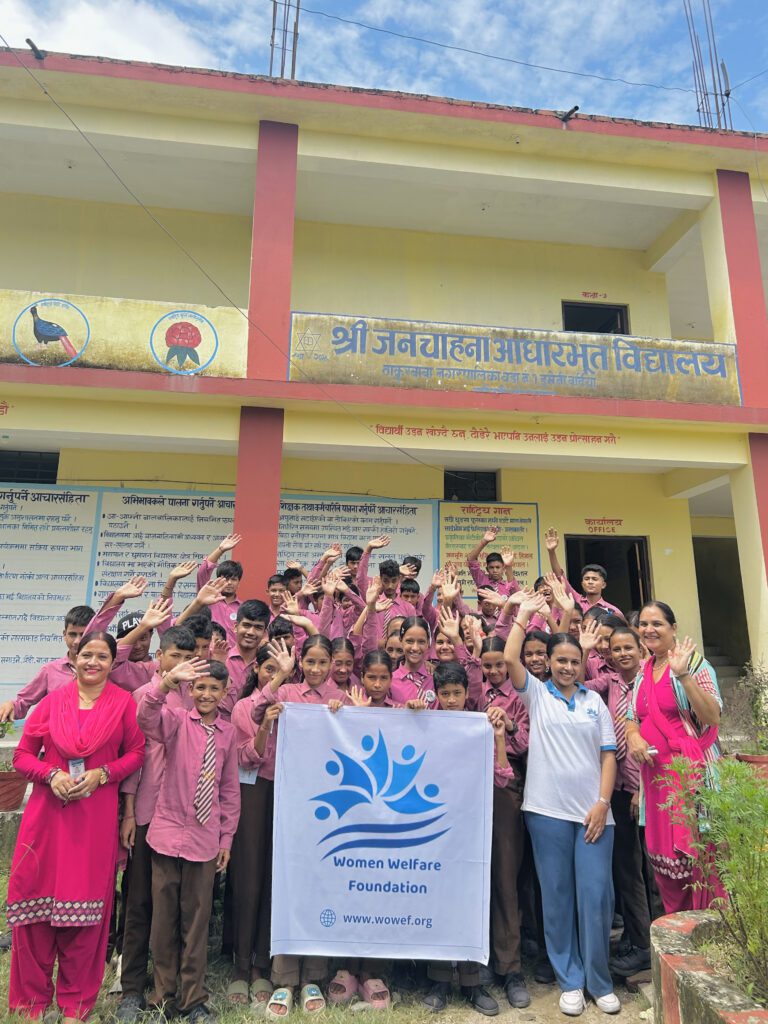 Garima and the Women Welfare Foundation team surrounded by happy children they have been teaching. Everyone has a hand up in celebration