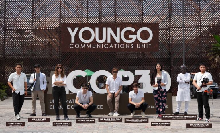 The YOUNGO communications unit, standing infront of the COP30 wall with their name hung behind them