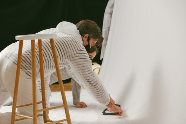 Two people setting up the backdrop for Fake Blood film