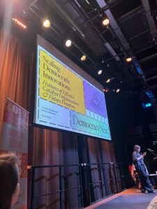 This image shows the first slide of the talk - titled 'Scaling Democratic Innovations'