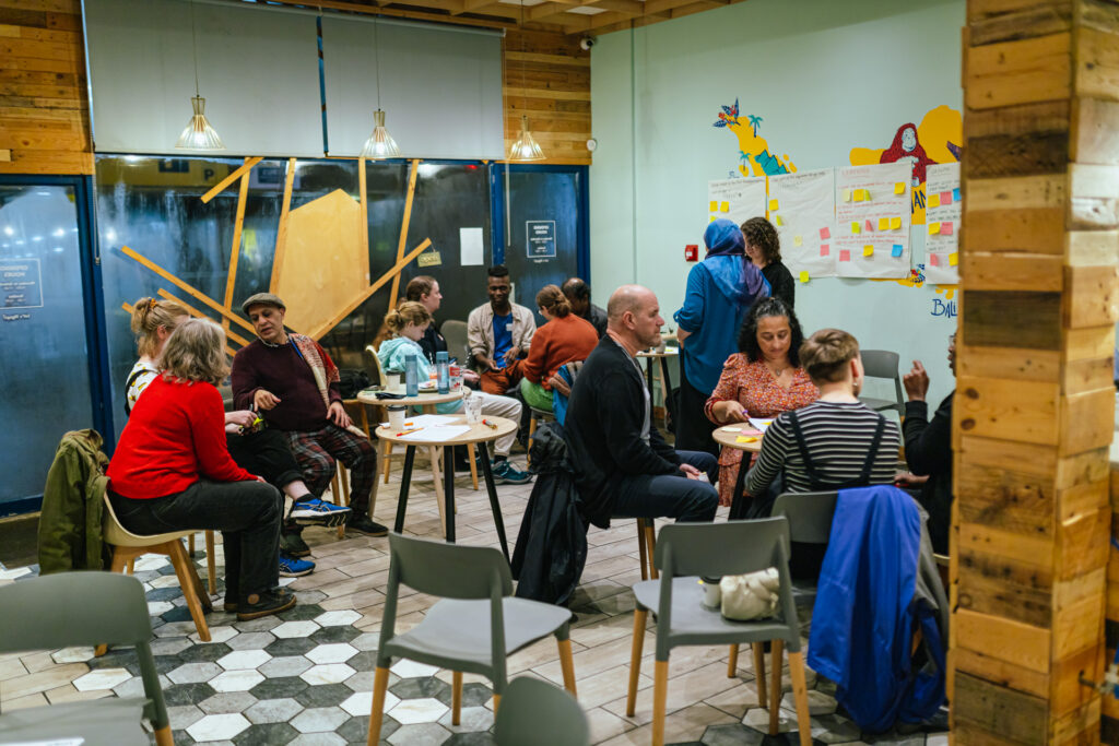 A diverse group of people take part in a Peoples Economy workshop