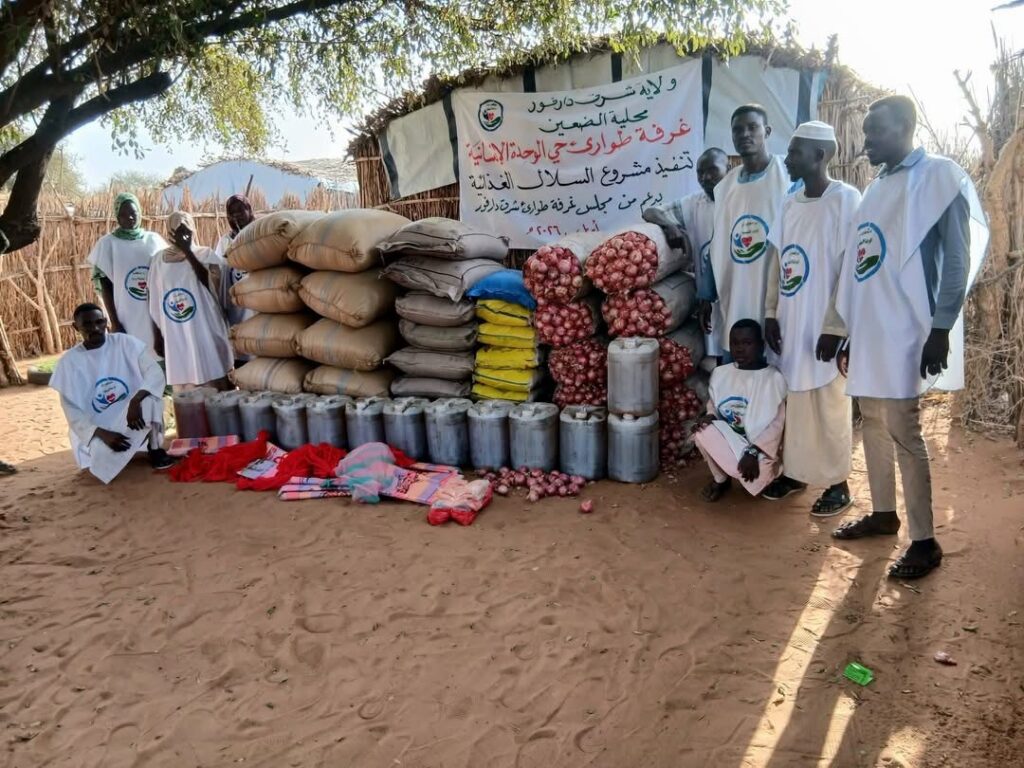Locals and volunteers gather around a stock of supplies, funded by the Sudan ERRs