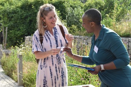 Rufaro helping Rufaro helping an attendee at an event in the sun